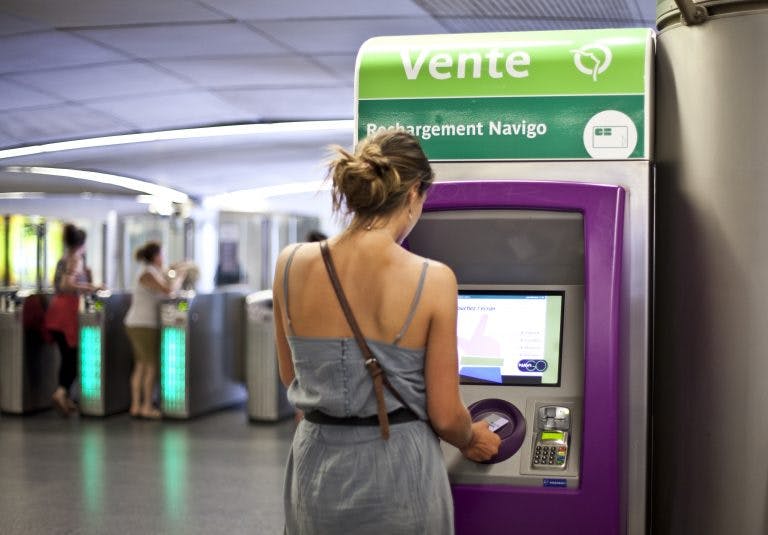 Voyageur qui recharge sa carte sur une borne de recharge