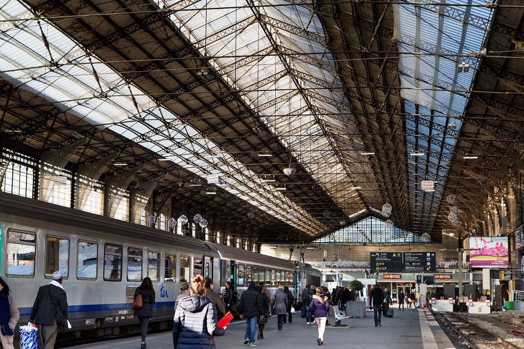 Voyageurs qui se dirigent vers un train dans la gare
