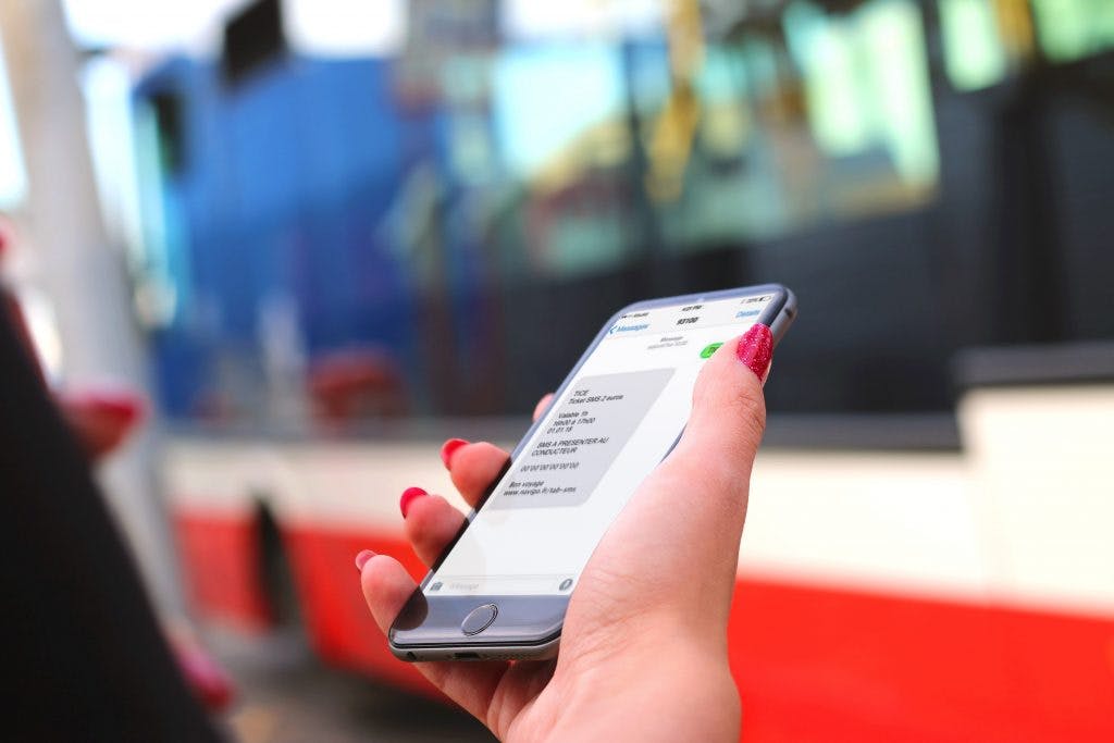 Téléphone dans la main présentant un ticket sms