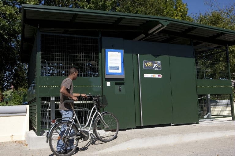 Utilisateur vélo qui ramène son vélo dans un espace Véligo sécurisé