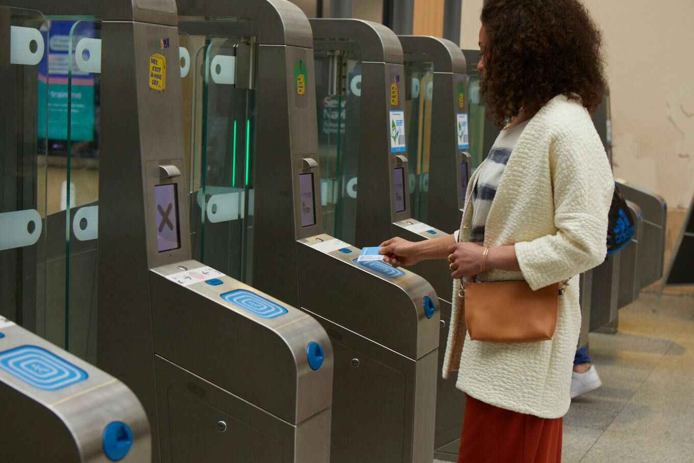 A woman validates her ticket at a metro or train station