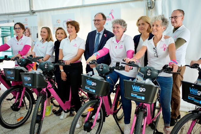 La Présidente d'Île-de-France Mobilités Valérie Pécresse et le Professeur Alain Puisieux, Président du Directoire de l'Institut Curie, le 1ᵉʳ octobre 2024, avec les bénévoles de l'association Casiopeea et les dix vélos roses Véligo prêtés pour octobre Rose. © Nicolas Gouhier