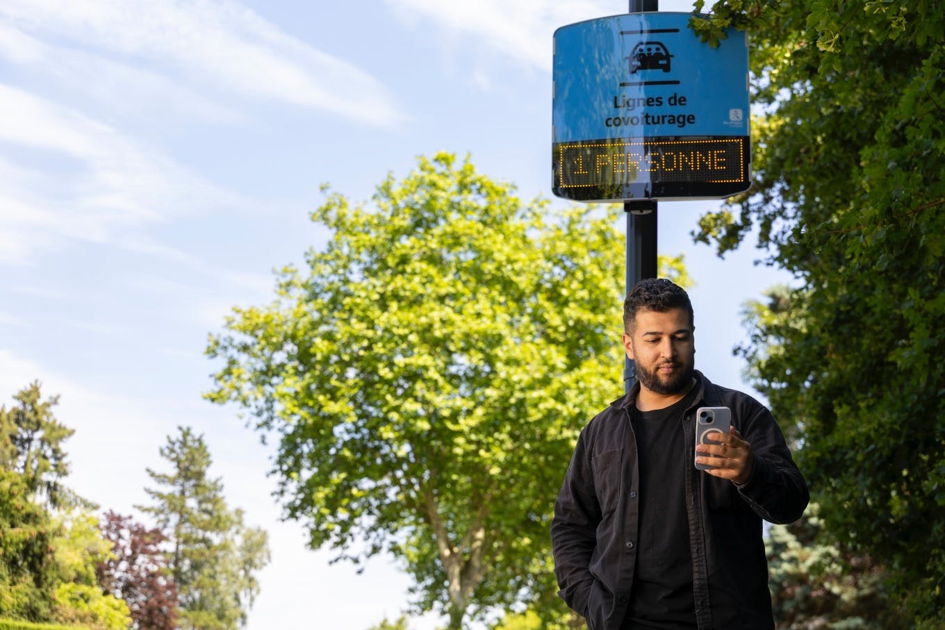 Un jeune homme attend le covoiturage à l'arrêt. - Ecov - Gwenn Dubourthoumieu