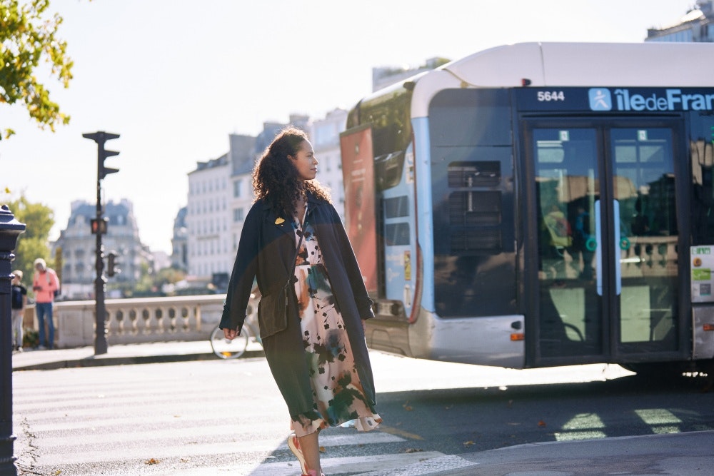Yoann STOECKEL / Group SJR / VHM / IDFM - Une jeune femme traverse au passage clouté à Paris avec un bus en fond.
