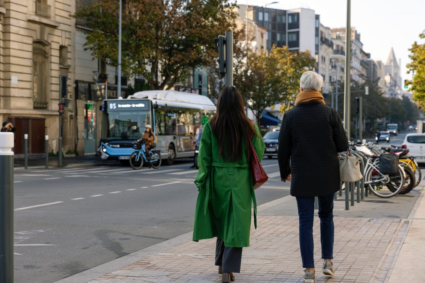 Duas mulheres caminham pela rua, com um ônibus ao longe. © Île-de-France Mobilités