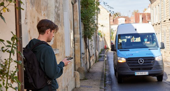 Un homme sur son téléphone attendant son transport à la demande