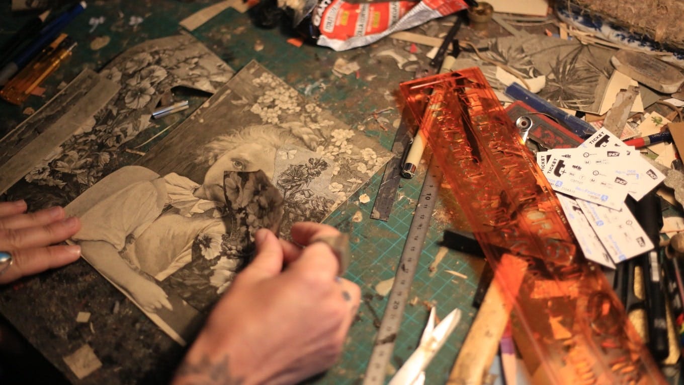 l'artiste Madame travaille sur un collage dans son atelier