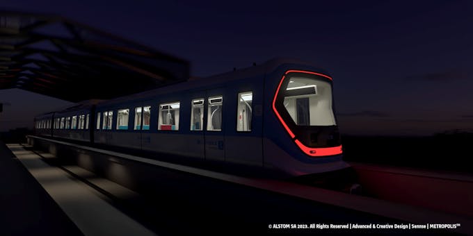 Vue d'une future rame de la ligne de métro 18 en circulation dans la pénombre avec sa face lumineuse caractéristique.