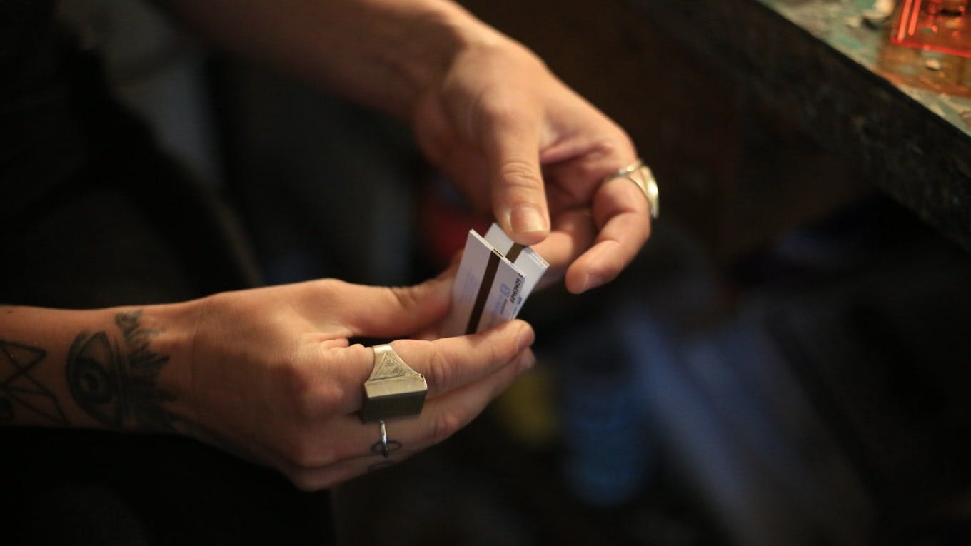 Les mains de l'artiste Madame et un carnet de tickets t+