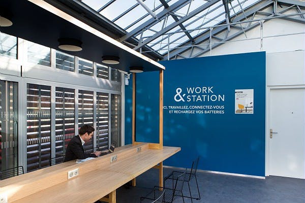 Voyageur qui travail dans un espace de travail moderne et connecté en gare